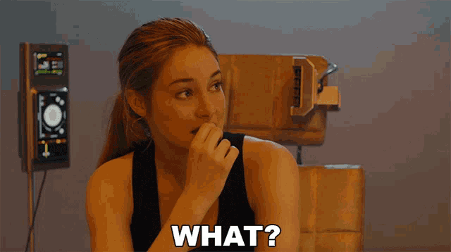 a woman in a black tank top with the word what on her chest