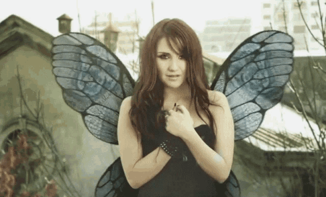 a woman in a black dress with blue wings