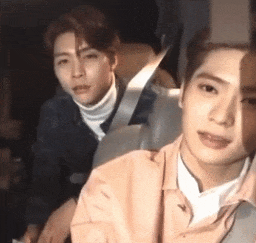 a couple of young men are sitting in a car .