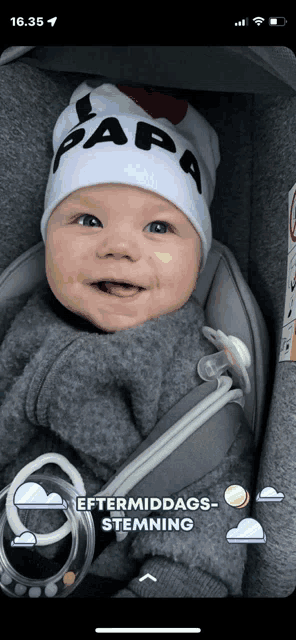 a baby wearing a white hat with papa on it