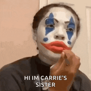 a woman is wearing a clown makeup and applying red lipstick to her lips .
