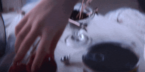 a close up of a person 's hand reaching into a glass