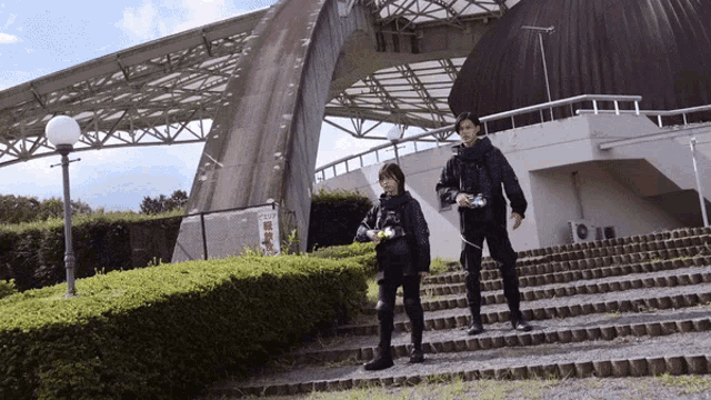 two people walking down stairs in front of a building with chinese writing