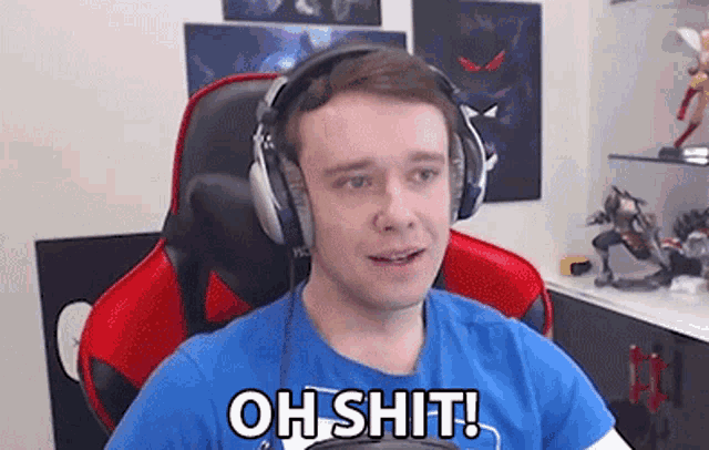 a man wearing headphones is sitting in a gaming chair and saying oh shit .