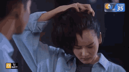 a man is touching a woman 's hair with the number 35 on the bottom