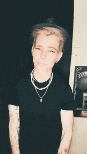 a blurry picture of a man with a necklace that says ' i 'm sorry ' on it