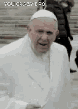 the pope is wearing a white suit and a white hat and is laughing .