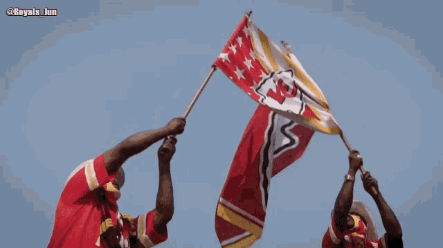 two men holding up a chiefs flag with the hashtag royals jun