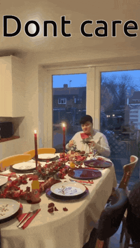 a woman sits at a table with plates and candles and a sign that says dont care