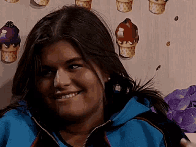 a woman in a blue jacket is smiling in front of an ice cream cone wallpaper .