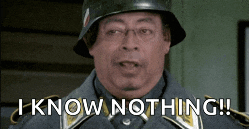 a man wearing a helmet and glasses says i know nothing