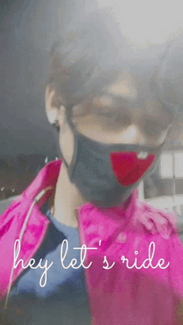 a person wearing a mask and a pink jacket with the words hey let 's ride