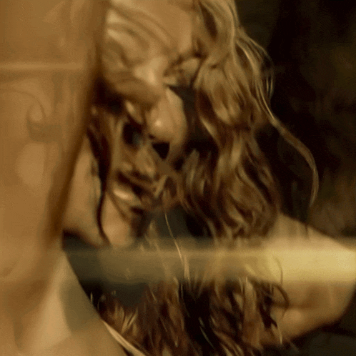 a close up of a woman 's face with a reflection of her in a mirror