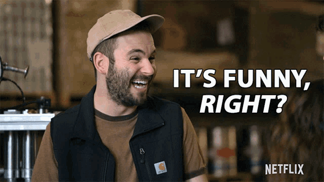 a man wearing a vest that says carhartt on it is smiling and says it 's funny right