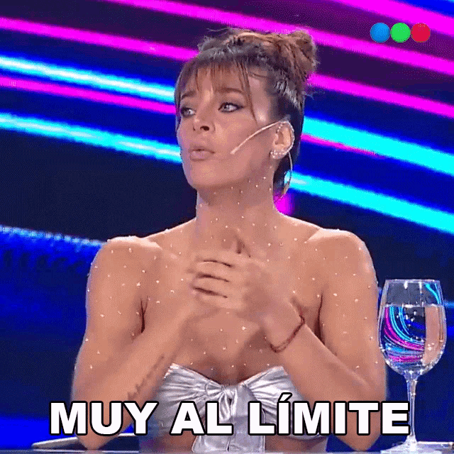 a woman sitting at a table with a glass of water says muy al limite