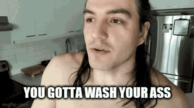 a shirtless man with long hair is in a kitchen and says you gotta wash your ass
