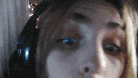 a woman wearing headphones looks at the camera