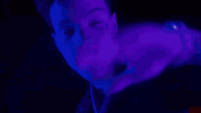 a close up of a person 's face with a blue light behind it