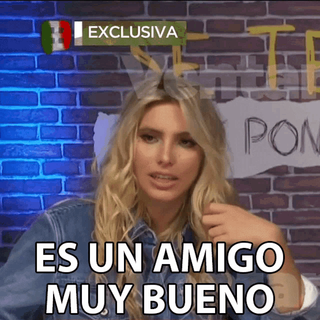 a woman says " es un amigo muy bueno " while standing in front of a brick wall