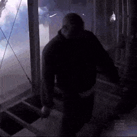 a man is walking down stairs in a dark room .