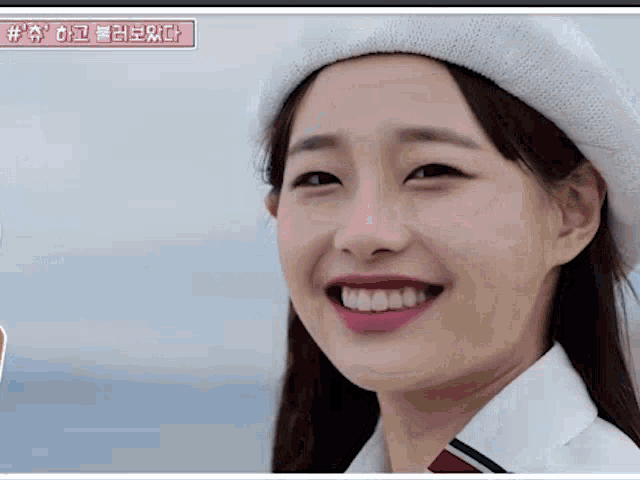 a close up of a woman wearing a white beret and smiling