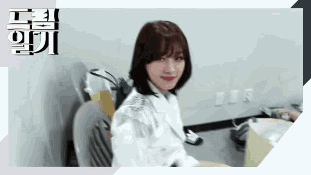 a woman in a white jacket sits in a chair in front of a sign that says ' korean ' on it