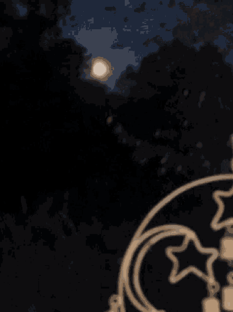 a full moon is visible in the night sky behind a crescent moon and stars