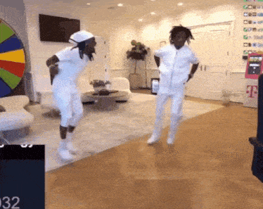 two men are dancing in a living room in front of a t mobile sign .