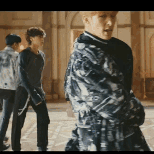 a group of men are standing next to each other in a room and dancing .