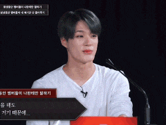 a young man in a white shirt is sitting in front of a microphone with korean writing on it
