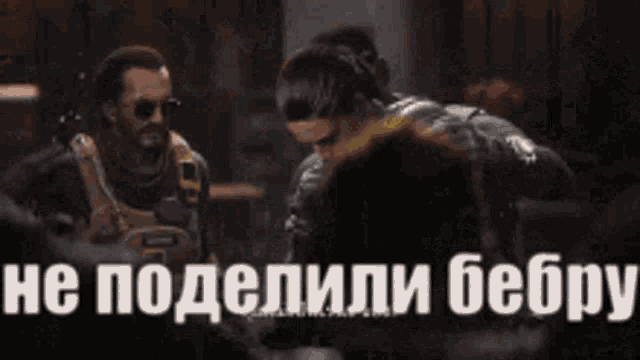 a man and a woman are sitting next to each other in a dark room with russian writing on the bottom of the image .