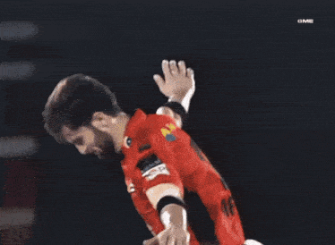 a soccer player wearing a number 10 jersey holds his arm up in the air
