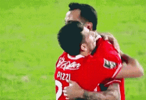 two soccer players are hugging each other and one of them has the number 3 on his jersey