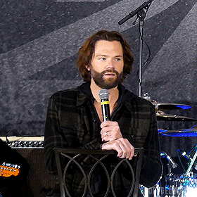 a man with a beard is holding a microphone