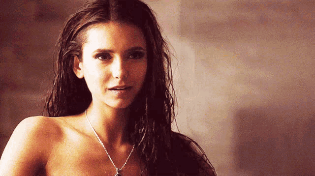 a woman without a shirt is wearing a necklace