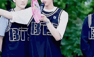 a group of young men are standing next to each other wearing jerseys that say bts on them .