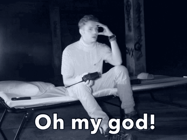 a man is sitting on a bed holding a walkie talkie with the words oh my god below him