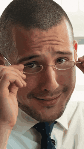 a man wearing glasses and a tie is making a funny face