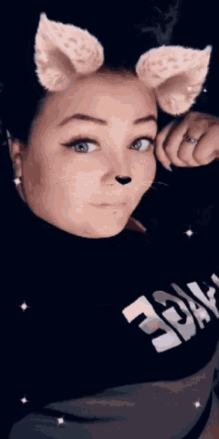 a woman wearing cat ears and a ring looks at the camera