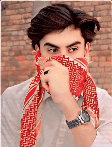 a man covering his face with a red scarf