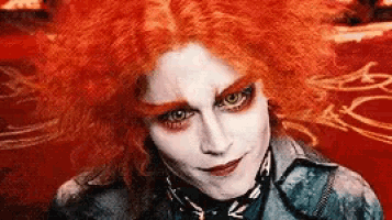 a close up of a person 's face with red hair .