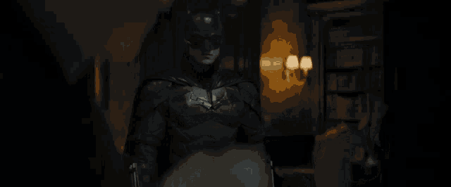 a man in a bat suit is standing next to a woman in a white shirt .