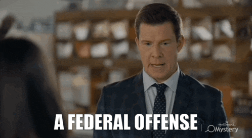 a man in a suit and tie is talking to a woman and says " a federal offense "