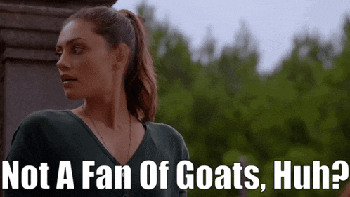 a woman stands in front of a sign that says " not a fan of goats huh ? "