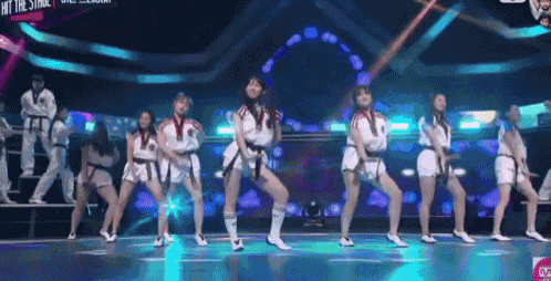 a group of women are dancing on a stage with a sign that says hit the stage