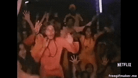 a crowd of people are dancing at a concert in a dark room .