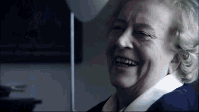 a close up of an elderly woman laughing with her eyes closed