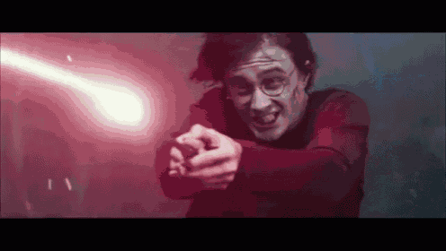 harry potter is holding a sword in his hand and pointing it at someone .