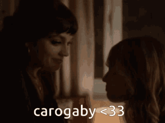 two women are looking at each other and the words carogaby < 33 are visible