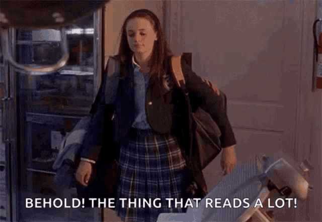 a girl in a school uniform is holding a pile of papers and a bag .